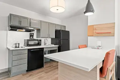 a kitchen with a white counter top and a black refrigerator at Candlewood Suites Hazleton by IHG in Hazleton