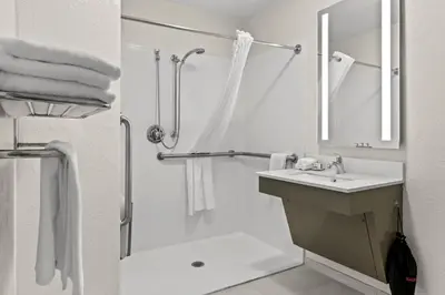 a white bathroom with a shower and a sink at Candlewood Suites Hazleton by IHG in Hazleton