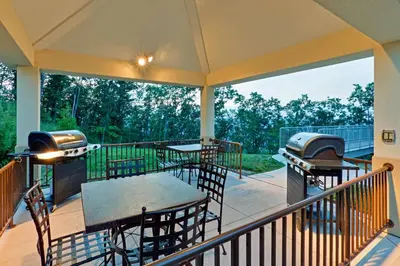 a screened porch with tables and a grill at Candlewood Suites Hazleton by IHG in Hazleton