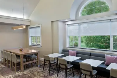 a dining room with a table and chairs and windows at Residence Inn Wayne in Wayne