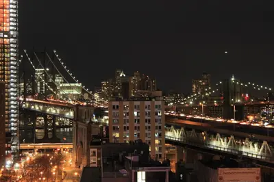 a city skyline at night with a bridge and buildings at Hotel Richland LES in New York