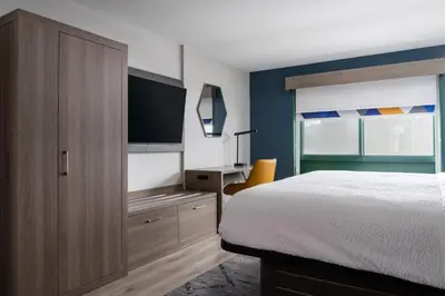 a bedroom with a bed and a desk with a television at Holiday Inn Express Hotel & Suites Drums-Hazelton by IHG in Drums