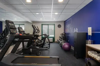 a gym with cardio equipment and a blue wall at Holiday Inn Express Hotel & Suites Drums-Hazelton by IHG in Drums