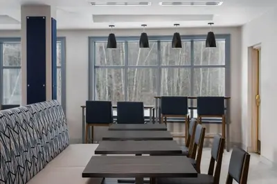 a dining room with a long table and blue chairs at Holiday Inn Express Hotel & Suites Drums-Hazelton by IHG in Drums