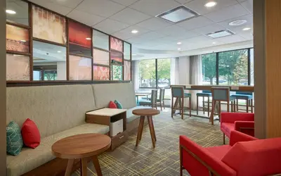 a waiting room with a couch and tables and chairs at Hampton Inn by Hilton Harrisburg West in Mechanicsburg
