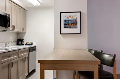 a small kitchen with a wooden table and a sink at Homewood Suites Lansdale in Lansdale