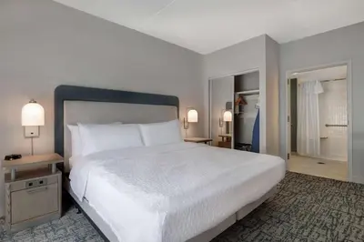 a bedroom with a large white bed and a bathroom at Homewood Suites Lansdale in Lansdale