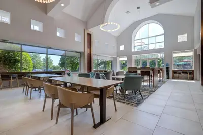 a dining room with tables and chairs and windows at Homewood Suites Lansdale in Lansdale