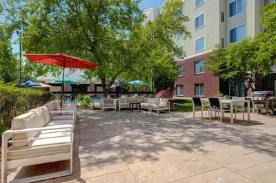 a patio with tables and chairs and a red umbrella at Homewood Suites Lansdale in Lansdale