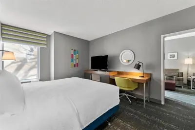 a hotel room with a bed and a desk with a computer at Hampton Inn & Suites Newtown in Yardley