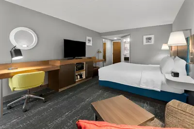 a hotel room with a bed and a desk with a television at Hampton Inn & Suites Newtown in Yardley