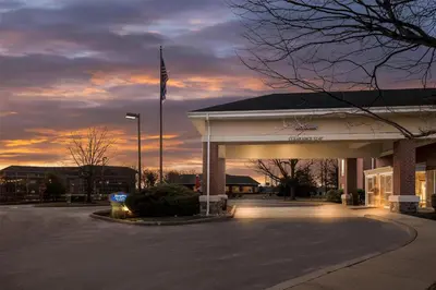 an empty parking lot in front of a building with a flag at Hampton Inn & Suites Newtown in Yardley