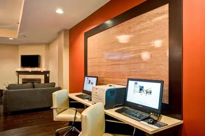 a office with two laptops on a desk with a couch at Hampton Inn Scranton at Montage Mountain in Scranton