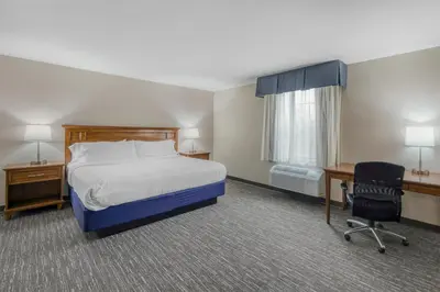 a hotel room with a bed and a desk and a chair at SureStay Plus Hotel by Best Western Elizabethtown Hershey in Elizabethtown