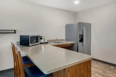 a kitchen with a counter and a refrigerator at SureStay Plus Hotel by Best Western Elizabethtown Hershey in Elizabethtown