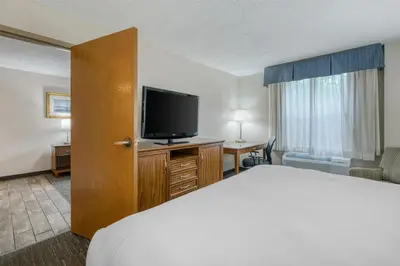 a hotel room with a bed and a flat screen tv at SureStay Plus Hotel by Best Western Elizabethtown Hershey in Elizabethtown