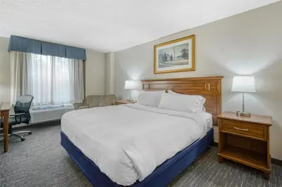a hotel room with a large bed and a desk at SureStay Plus Hotel by Best Western Elizabethtown Hershey in Elizabethtown