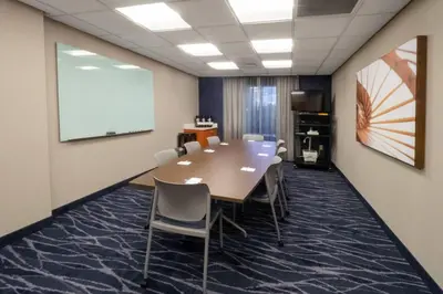 a conference room with a table and chairs and a whiteboard at Fairfield Inn by Marriott Hazleton in Hazleton