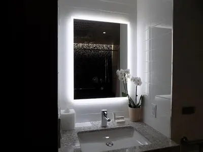 a bathroom with a sink with a mirror and flowers at Carnegie Hotel in New York