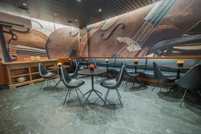a restaurant with tables and chairs and a mural at Carnegie Hotel in New York