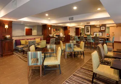 a restaurant with tables and chairs and a bar at Hampton Inn South Plainfield-Piscataway in South Plainfield