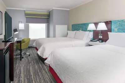 a hotel room with two beds and a desk at Hampton Inn South Plainfield-Piscataway in South Plainfield