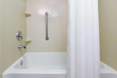 a white bath tub with a shower curtain in a bathroom at Hampton Inn South Plainfield-Piscataway in South Plainfield