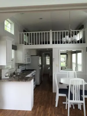 a kitchen with a table and a dining room at Circle M Camping Resort Loft Park Model in Wabank