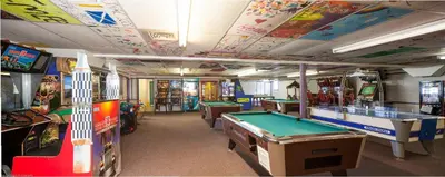 a room with several arcade games and pool tables at Circle M Camping Resort Loft Park Model in Wabank