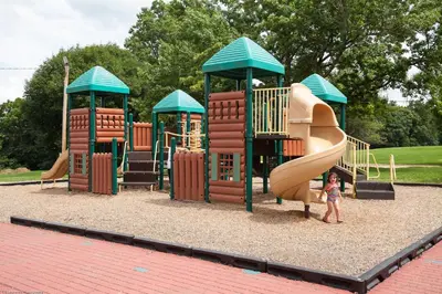 a child standing in front of a playground at Circle M Camping Resort Screened Park Model in Wabank