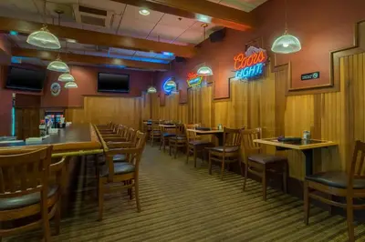 a dining room with wooden tables and chairs at Holiday Inn Harrisburg I-81 Hershey Area by IHG in Grantville