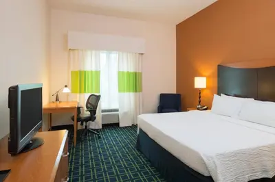 a hotel room with a bed and a desk and a television at Fairfield Inn & Suites Lock Haven in Lock Haven
