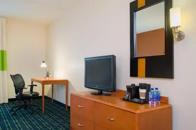 a room with a television on a dresser with a mirror at Fairfield Inn & Suites Lock Haven in Lock Haven