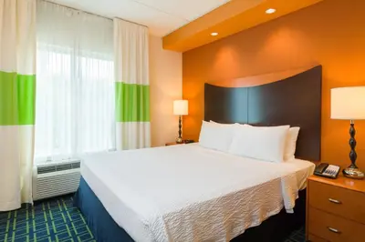 a hotel room with a bed and a large window at Fairfield Inn & Suites Lock Haven in Lock Haven