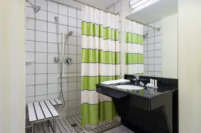 a bathroom with a sink and a green shower curtain at Fairfield Inn & Suites Lock Haven in Lock Haven