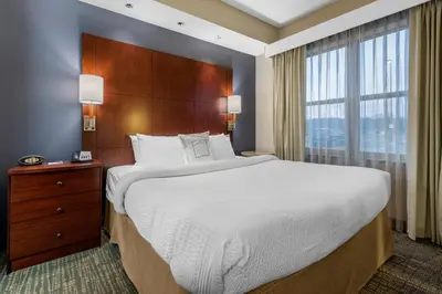 a bedroom with a large bed and a large window at Residence Inn by Marriott Hazleton in Hazleton