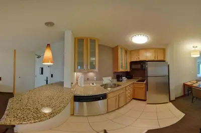 a kitchen with wooden cabinets and a stainless steel refrigerator at Residence Inn by Marriott Hazleton in Hazleton