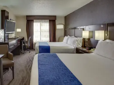 a hotel room with two beds and a desk at Holiday Inn Express Hotel & Suites Meadowlands Area by IHG in Carlstadt