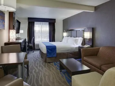 a hotel room with a bed and a couch at Holiday Inn Express Hotel & Suites Meadowlands Area by IHG in Carlstadt