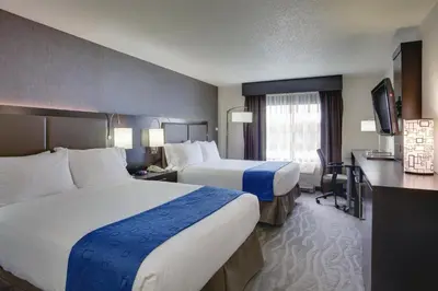 a hotel room with two beds and a television at Holiday Inn Express Hotel & Suites Meadowlands Area by IHG in Carlstadt