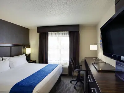 a hotel room with a bed and a flat screen tv at Holiday Inn Express Hotel & Suites Meadowlands Area by IHG in Carlstadt