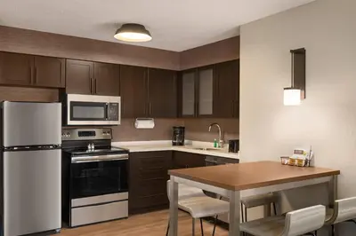 a kitchen with a white refrigerator and a table at Residence Inn Scranton in Scranton
