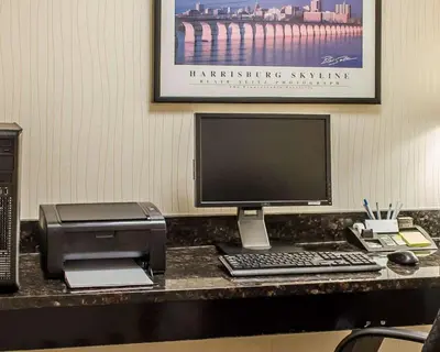a desk with a computer and a printer and a monitor at Hotel Hanna in Harrisburg