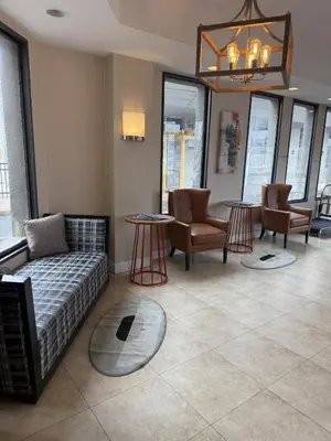 a living room with a couch and chairs and a chandelier at Hotel Hanna in Harrisburg
