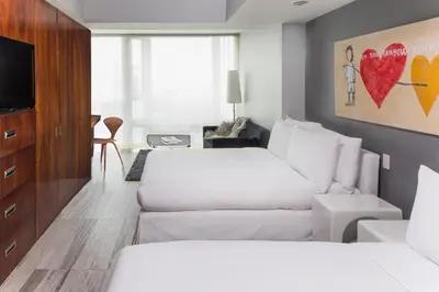 a hotel room with two beds and a couch at Hotel on Rivington in New York