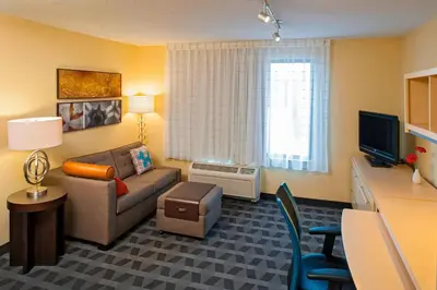 a small living room with a couch and a tv at TownePlace Suites by Marriott Bethlehem Easton/Lehigh Valley in Hollo