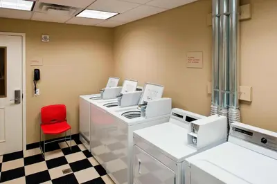 a waiting room with a red chair and machines at TownePlace Suites by Marriott Bethlehem Easton/Lehigh Valley in Hollo