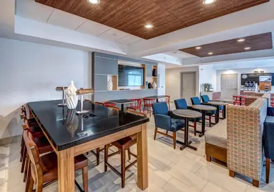 a bar with chairs and tables in a room at Holiday Inn Express Woodbridge by IHG in Avenel