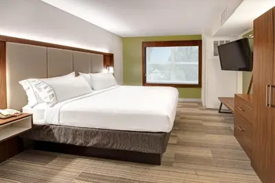 a bedroom with a large bed and a flat screen tv at Holiday Inn Express Woodbridge by IHG in Avenel
