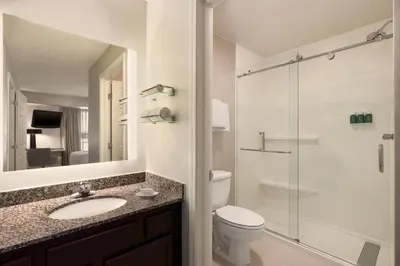 a bathroom with a toilet and a sink and a shower at Residence Inn Deptford in Almonesson